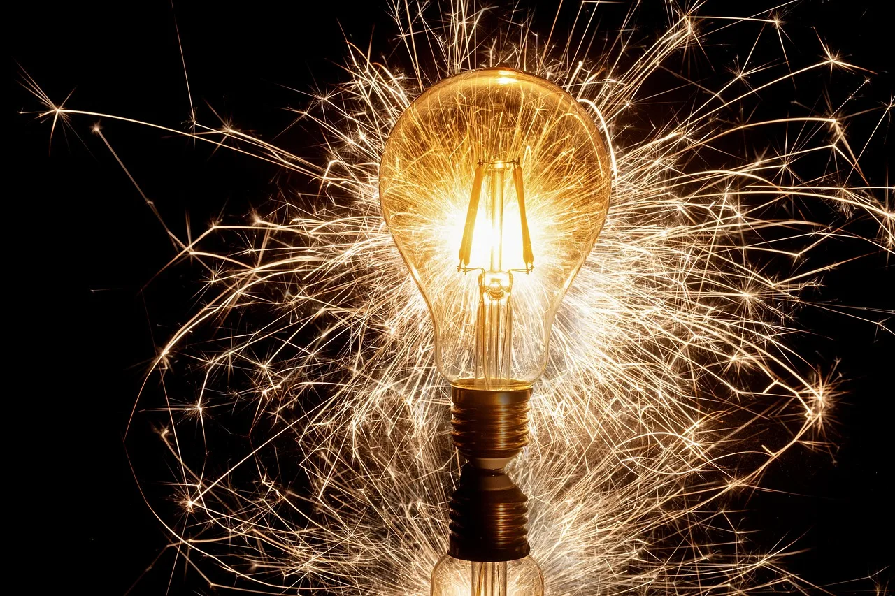 photo of a light bulb with firework/sparkler lights behind it